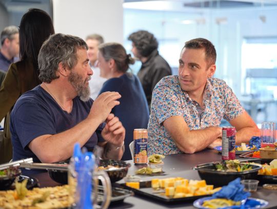 two employees talking at TIBO office lunch